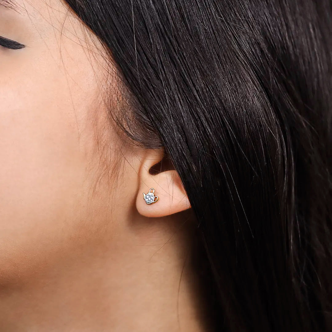 Oreja de mujer con topito en forma de tetera en oro de 18 quilates con cristales de color blanco hecho en joyeria caracas. 