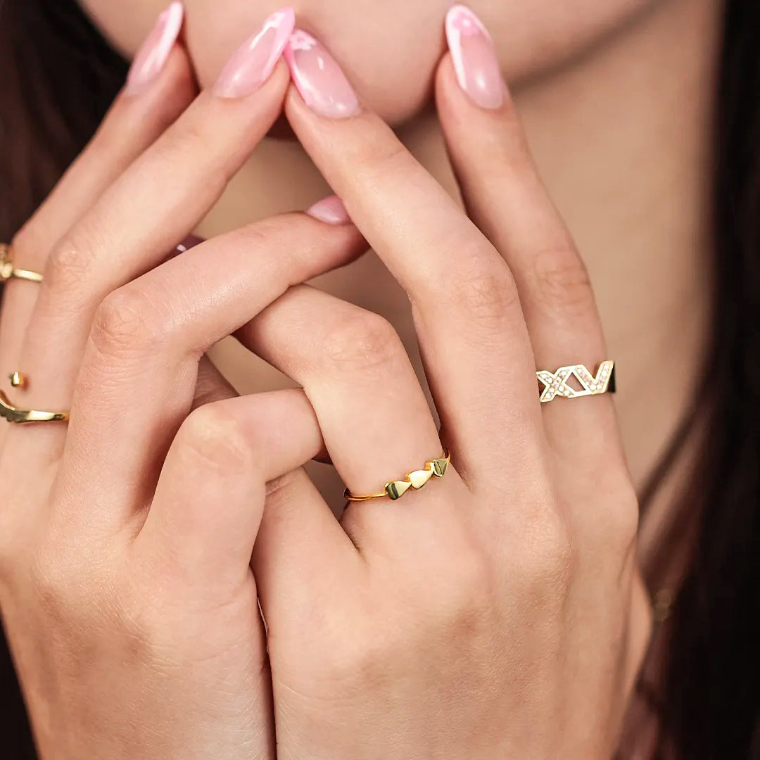 Mano con anillo de 3 corazones en oro amarillo de 18 quilates hecho en Joyería Caracas. 