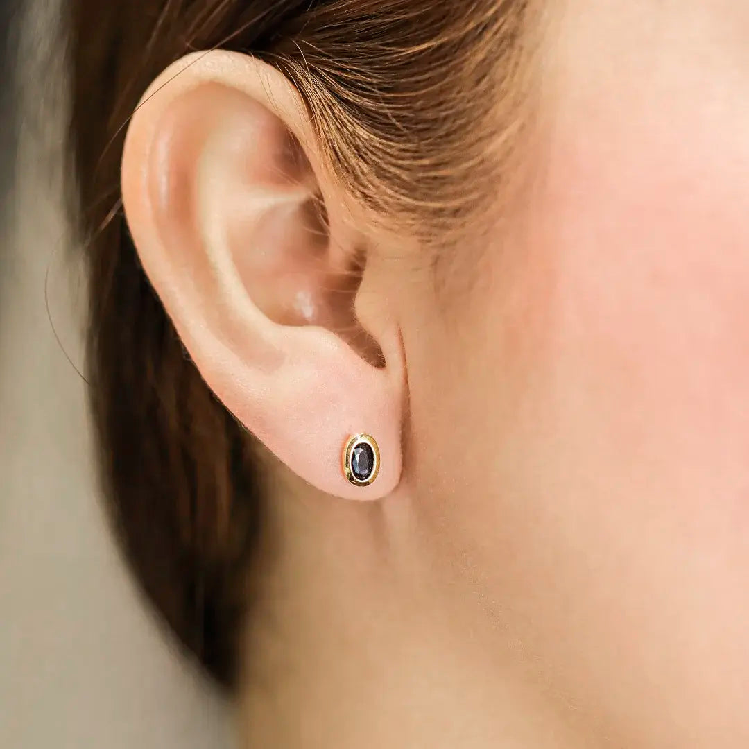 Oreja de mujer con topito en forma ovalada en oro amarillo de 18 quilates con Zafiro, hecho en Joyería Caracas. 