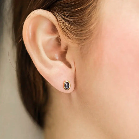 Oreja de mujer con topito en forma ovalada en oro amarillo de 18 quilates con Zafiro, hecho en Joyería Caracas. 