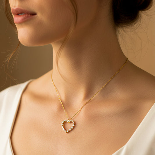 Cuello de mujer usando una gargantilla con dije en forma de corazón en oro amarillo de 18 quilates con cristales de color blanco de Joyería Caracas. 