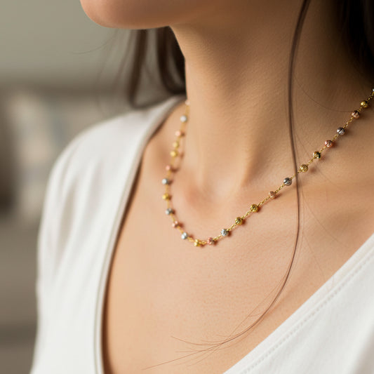 Cuello de mujer usando una gargantilla de esferas facetadas en 3 oros de 18 quilates de 45 cm de Joyería Caracas. 