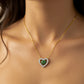 Cuello de mujer usando una gargantilla con forma de corazón en oro blanco con cristales y corazón en el centro en oro amarillo y cristales de color verde de Joyería Caracas. 