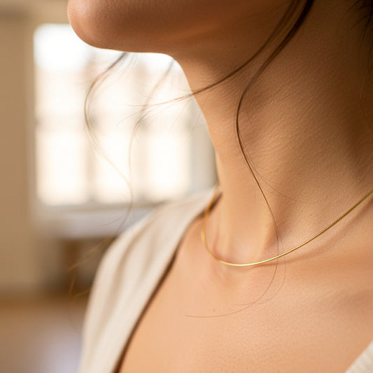 Cuello de mujer usando una gargantilla guaya espiga en oro amarillo de 18 quilates de Joyería Caracas. 