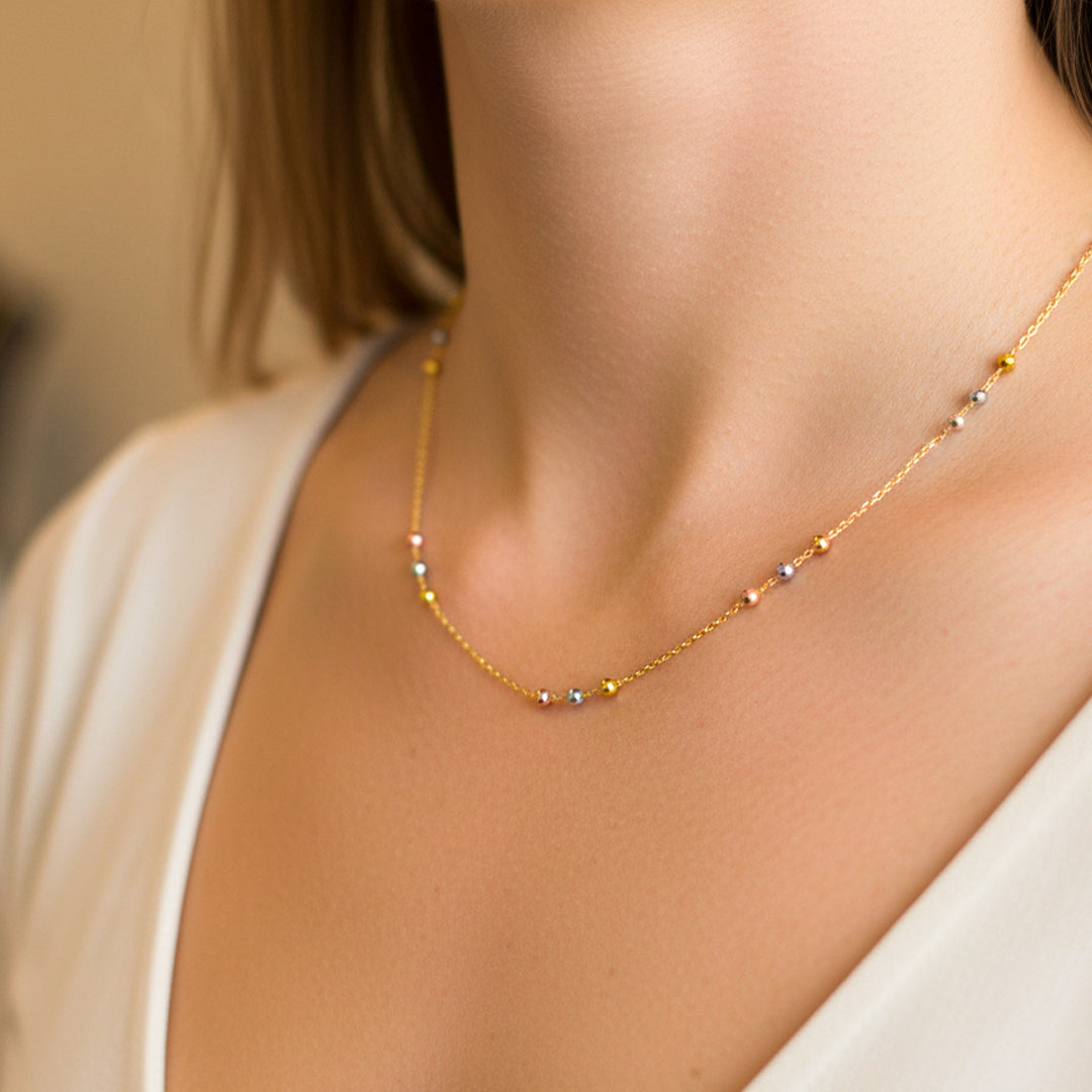 Cuello de mujer usando una gargantilla de esferas 3 oros de 18 quilates de Joyería Caracas. 