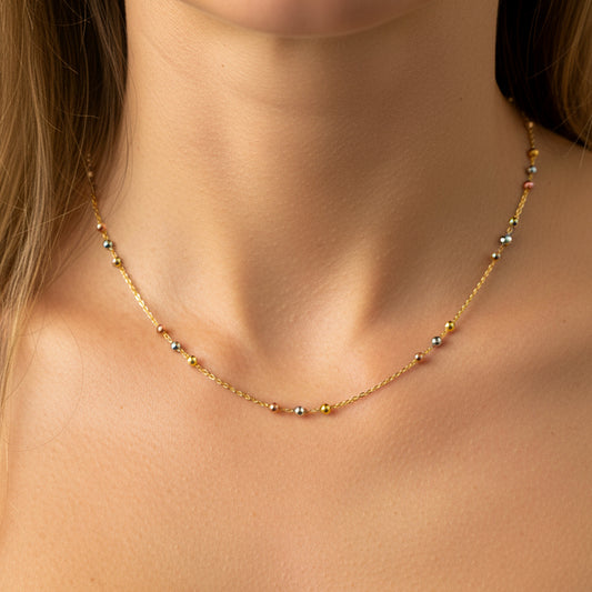 Cuello de mujer usando una gargantilla de esferas 3 oros de 18 quilates de Joyería Caracas. 