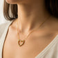 Cuello de mujer usando una gargantilla con cadena en tejido Venecia y dije de corazón en oro amarillo de 18 quilates con cristal de color blanco de Joyería Caracas. 