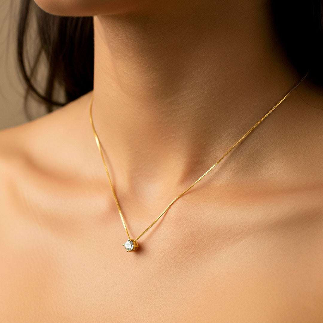 Cuello de mujer usando una gargantilla veneciana con dije pasante en oro amarillo de 18 quilates con cristal redondo de color blanco de Joyería Caracas. 