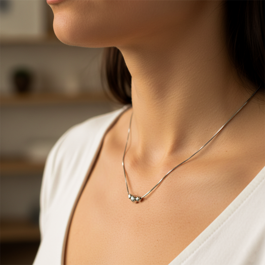Cuello de mujer usando una gargantilla con cadena en tejido Venecia con 3 esferas facetadas en oro blanco de 18 quilates de Joyería Caracas. 