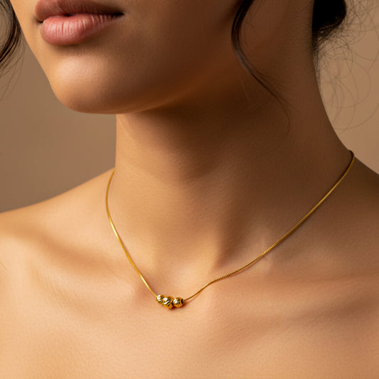 Cuello de mujer usando una gargantilla de cadena veneciana con 3 esferas facetadas en oro amarillo de 18 quilates de Joyería Caracas. 