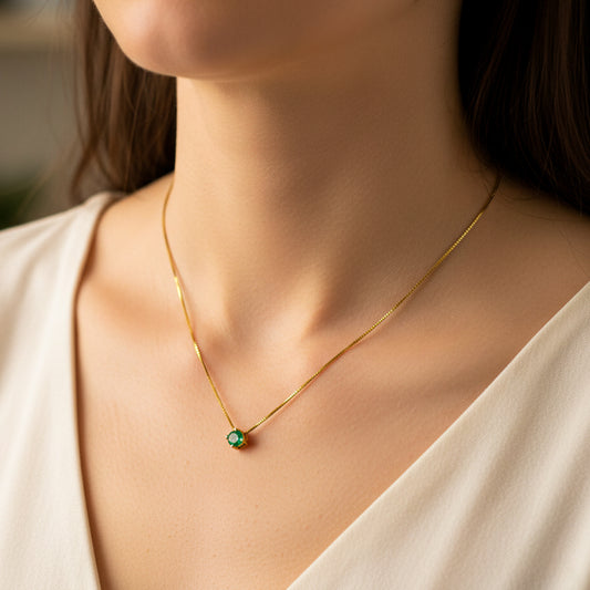 Cuello de mujer usando una gargantilla veneciana en oro amarillo de 18 quilates con dije pasante de Esmeralda de Joyería Caracas. 