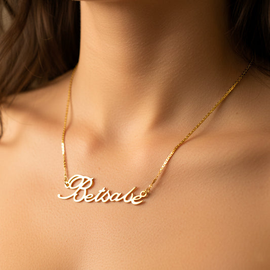 Cuello de mujer usando una gargantilla con cadena de nombre personalizado en oro amarillo de 18 quilates de Joyería Caracas. 