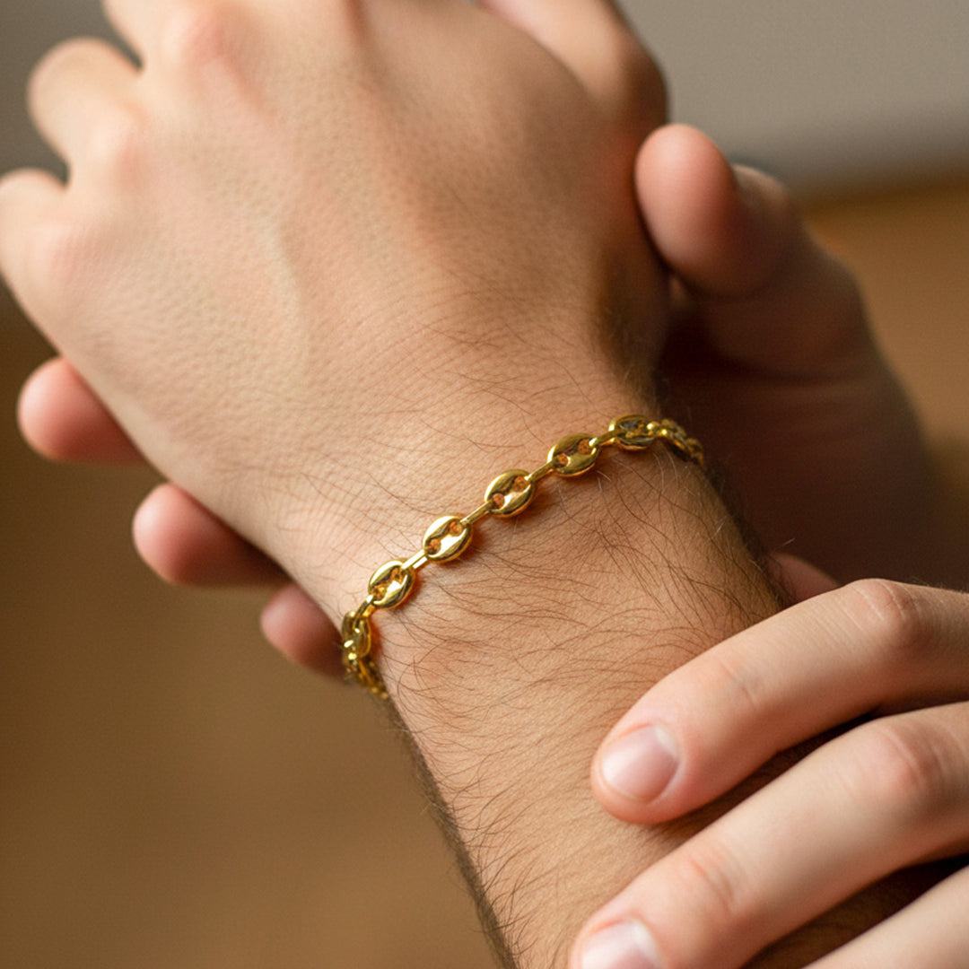 Mano de hombre usando una pulsera en tejido Calabrote en oro amarillo de 8 quilates de Joyería Caracas. 