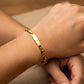 Mano de mujer usando una pulsera en tejido Calabrote con esclava en oro amarillo de 18 quilates de Joyería Caracas. 