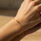 Mano de mujer usando una pulsera en tejido Classic en oro amarillo de 18 quilates de Joyería Caracas. 