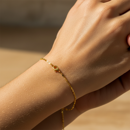 Mano de mujer usando una pulsera en tejido Classic en oro amarillo de 18 quilates de Joyería Caracas. 