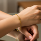 Mano de mujer usando una pulsera en tejido Classic Rolón en oro amarillo de 18 quilates de Joyería Caracas. 