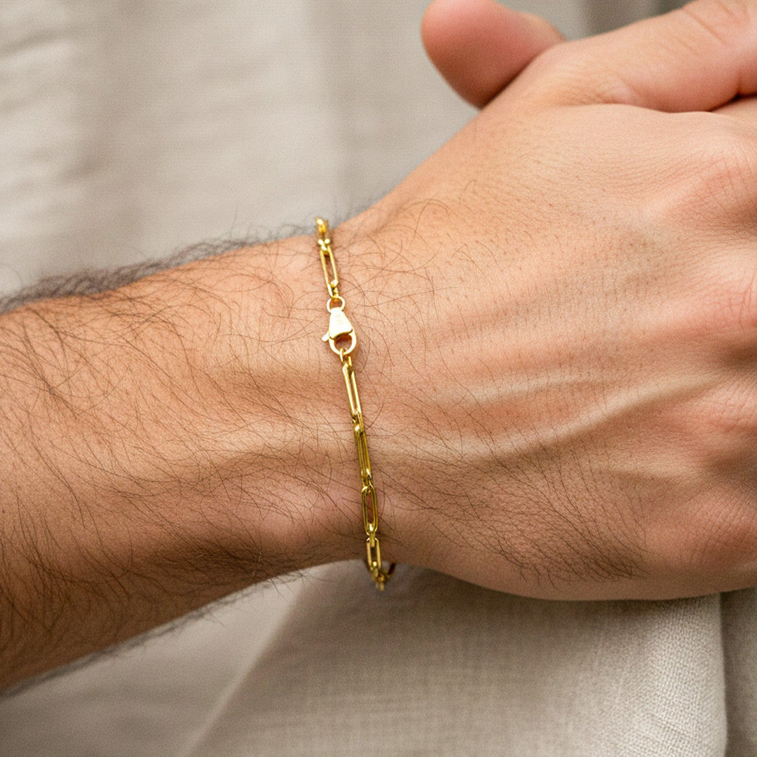 Mano de hombre usando una pulsera en tejido clips en oro amarillo de 18 quilates de Joyería Caracas. 
