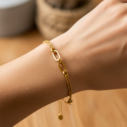 Mano de mujer usando una pulsera cubana con clips y círculos en oro amarillo de 18 quilates de Joyería Caracas. 