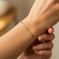 Mano de mujer usando una pulsera con formas de cuadrados - dados en 3 oros de 18 quilates de Joyería Caracas. 