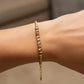 Mano de mujer usando una pulsera con esferas diamantadas de 3 oros de 18 quilates de Joyería Caracas. 