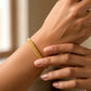 Mano de mujer usando una pulsera doble faz en oro amarillo de 18 quilates de Joyería Caracas. 