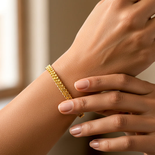 Mano de mujer usando una pulsera doble faz en oro amarillo de 18 quilates de Joyería Caracas. 