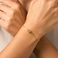 Mano de mujer usando una pulsera en tejido escalera plana con herraje de estrella en oro amarillo de 18 quilates de Joyería Caracas. 