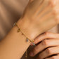 Mano de mujer usando una pulsera con formas de óvalos en oro amarillo y blanco de 18 quilates de Joyería Caracas. 