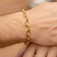 Mano de hombre usando una pulsera con eslabón de clips ovalados en oro amarillo de 18 quilates de Joyería Caracas. 