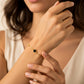 Mano de mujer usando una pulsera en oro amarillo van cleef de Joyería Caracas. 