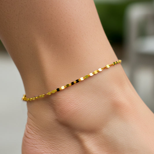 Tobillo de mujer la cual usa una tobillera en tejido bean style en oro amarillo de 18 quilates de Joyería Caracas. 