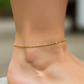 Tobillo de mujer la cual usa una tobillera en tejido classic diamantada en oro amarillo de 18 quilates de Joyería Caracas. 