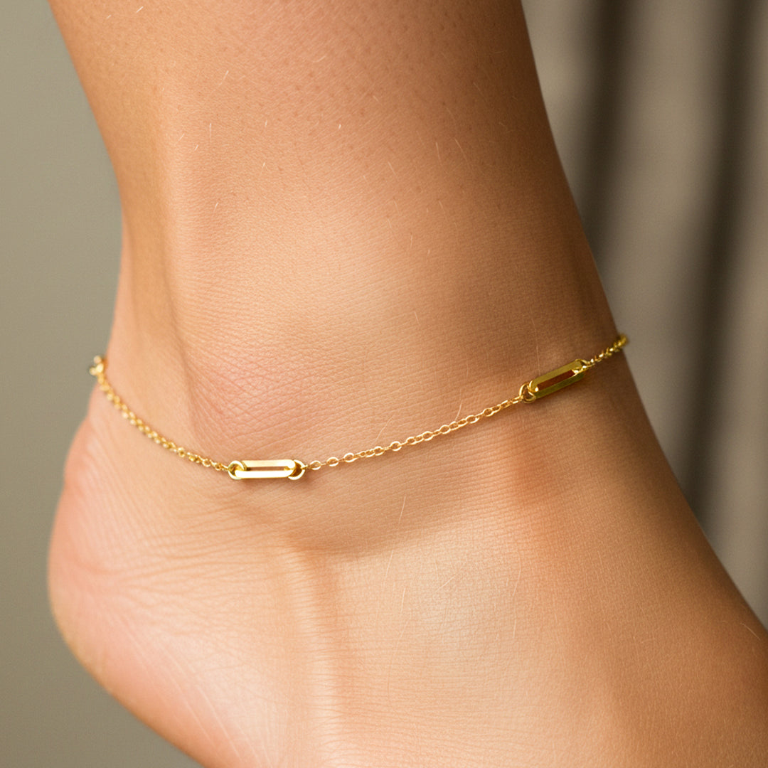 Tobillo de mujer usando una tobillera con clics en oro amarillo de 18 quilates de Joyería Caracas. 