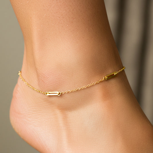 Tobillo de mujer usando una tobillera con clics en oro amarillo de 18 quilates de Joyería Caracas. 