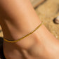 Tobillo de mujer la cual usa una tobillera en tejido cubano seguido en oro amarillo de 18 quilates de Joyería Caracas. 