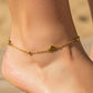 Tobillo de mujer la cual usa una tobillera con corazones y esferas en oro amarillo de 18 quilates de Joyería Caracas. 