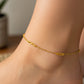 Tobillo de mujer la cual usa una tobillera de infinito con clip en oro amarillo de 18 quilates de Joyería Caracas. 