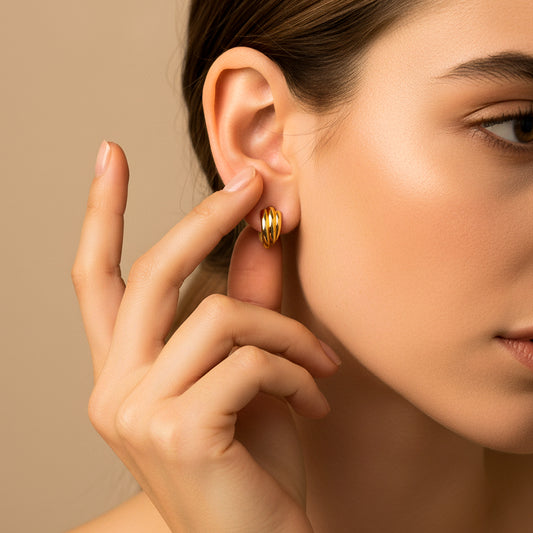 Oreja de modelo usando un topito en forma de abanico en oro amarillo de 18 quilates de Joyería Caracas. 