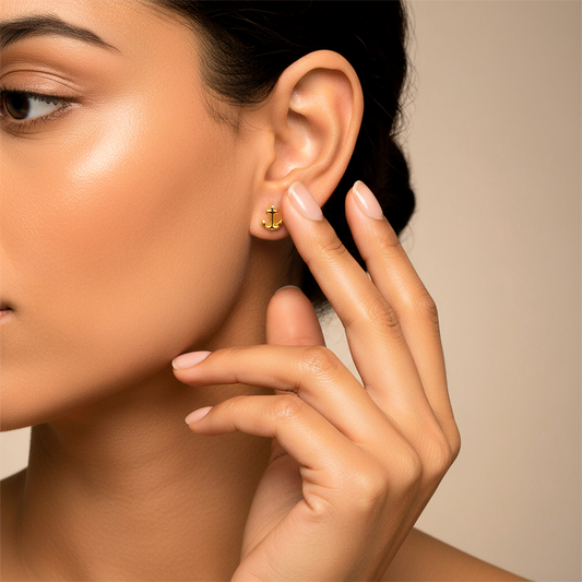 Oreja de modelo usando un topito en forma de ancla en oro amarillo de 18 quilates de Joyería Caracas. 