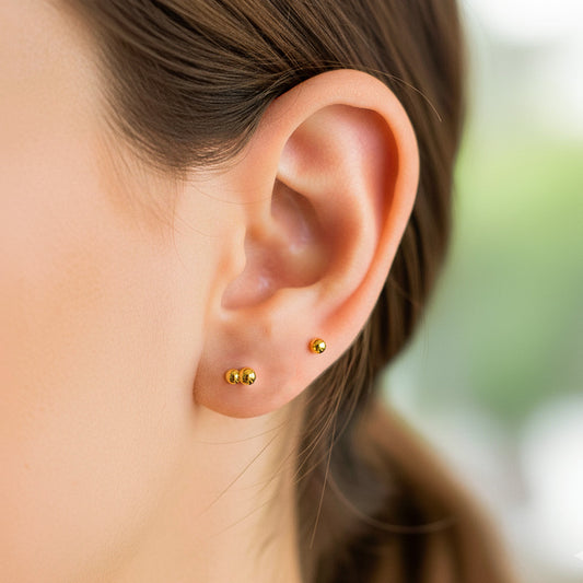 Oreja de modelo usando un topito en forma de hormiga en oro amarillo de 18 quilates de Joyería Caracas. 