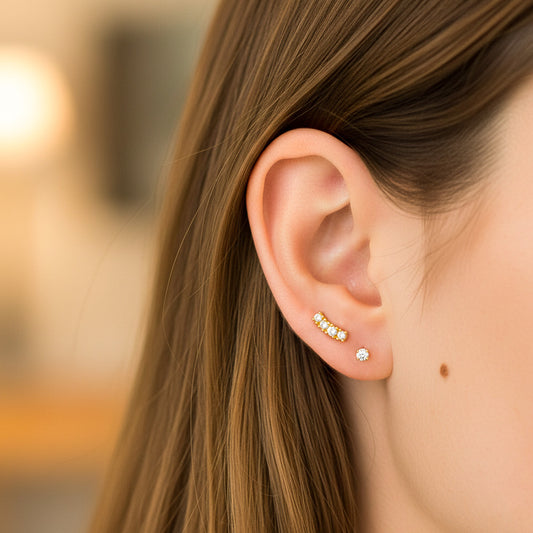 Oreja de modelo usando un topito en oro amarillo de 18 quilates con cristales de color blanco de Joyería Caracas. 