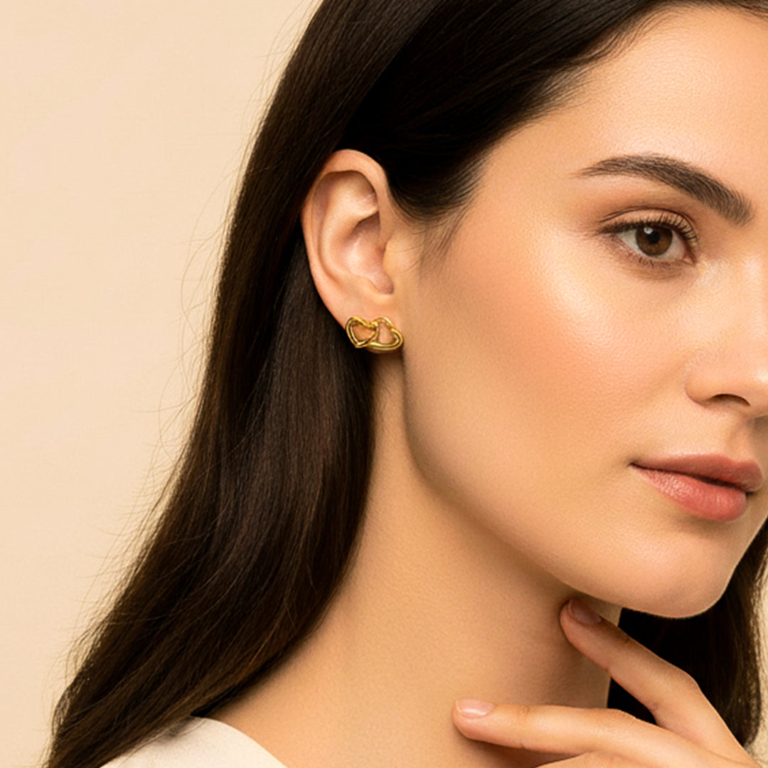 Oreja de modelo usando un topito de doble corazón en oro amarillo de 18 quilates de Joyería Caracas. 