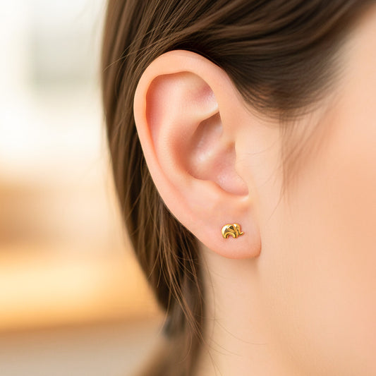 Oreja de modelo usando un topito en forma de elefante en oro amarillo de 18 quilates de Joyería Caracas. 