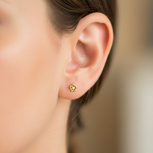Oreja de modelo usando un topito en forma de estrella calada en oro amarillo de 18 quilates con cristal de Joyería Caracas. 