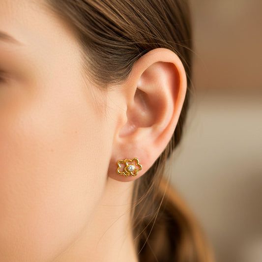 Oreja de modelo usando un topito en forma de flor calada doble en oro amarillo de 18 quilates de Joyería Caracas. 