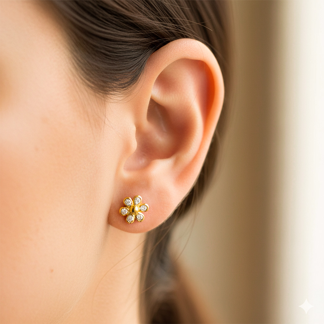 Oreja de modelo usando un topito en forma de flor en oro amarillo de 18 quilates con cristales de color blanco de Joyería Caracas. 