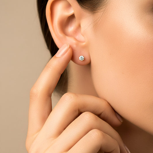 Oreja de modelo usando un topito en oro amarillo de 18 quilates con cristal de color blanco de Joyería Caracas. 