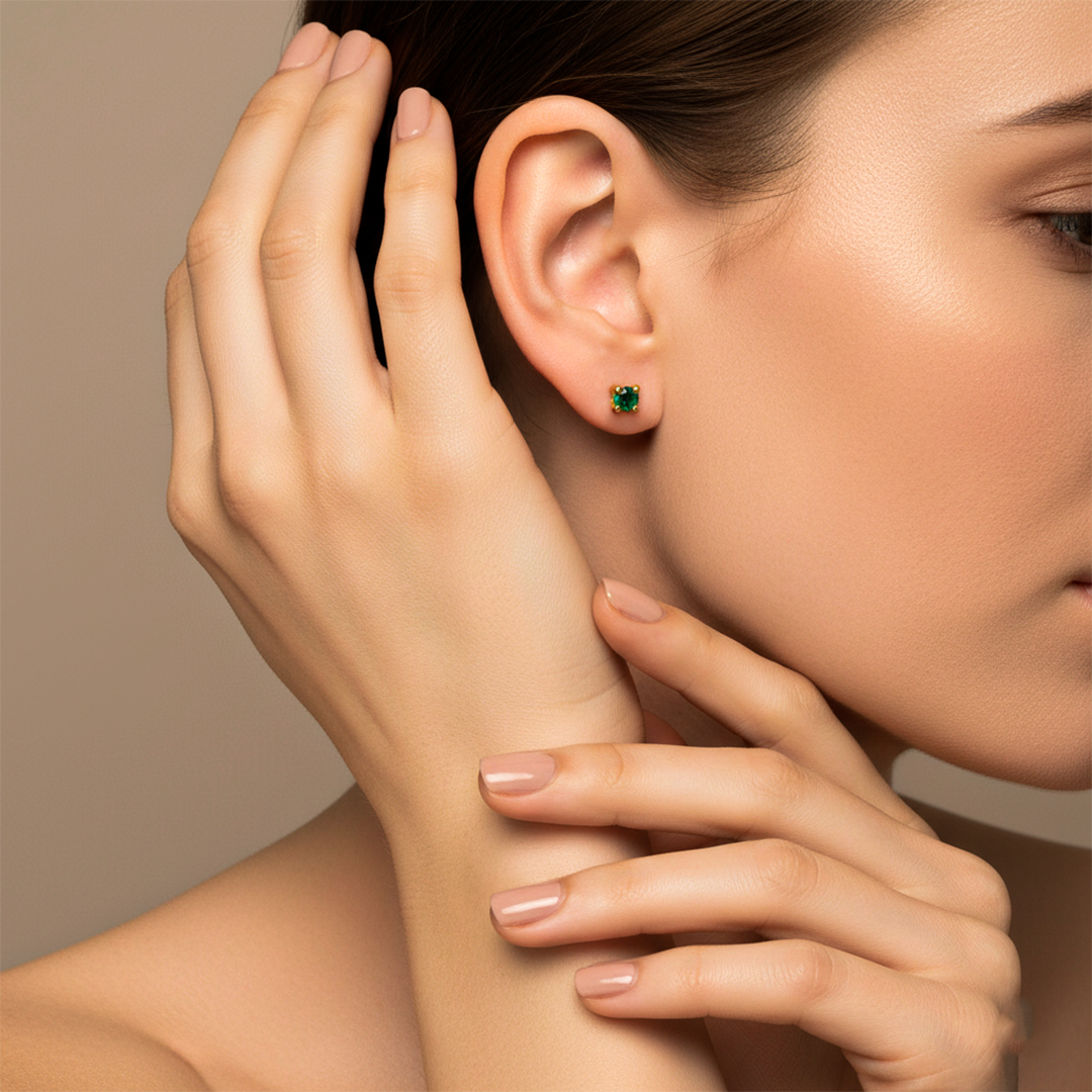 Oreja de modelo usando un topito en oro amarillo de 18 quilates con Esmeralda de Joyería Caracas. 