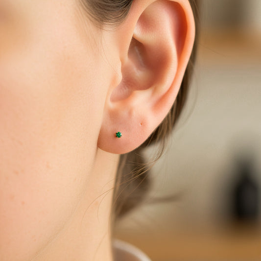 Oreja de modelo usando un topito en oro amarillo de 18 quilates con Esmeralda de Joyería Caracas. 